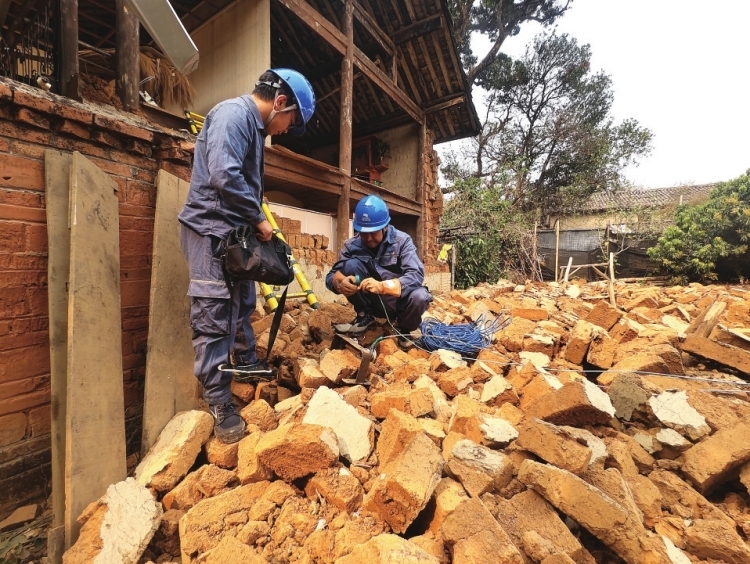 德宏陇川供电局章凤供电所对地震倒塌房屋墙面线路进行故障处理。 王治航 摄.jpg